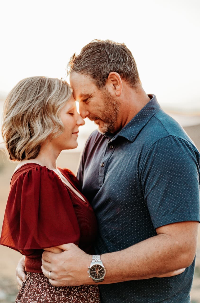 Couple embracing forehead to forehead, her in red, him in a navy polo