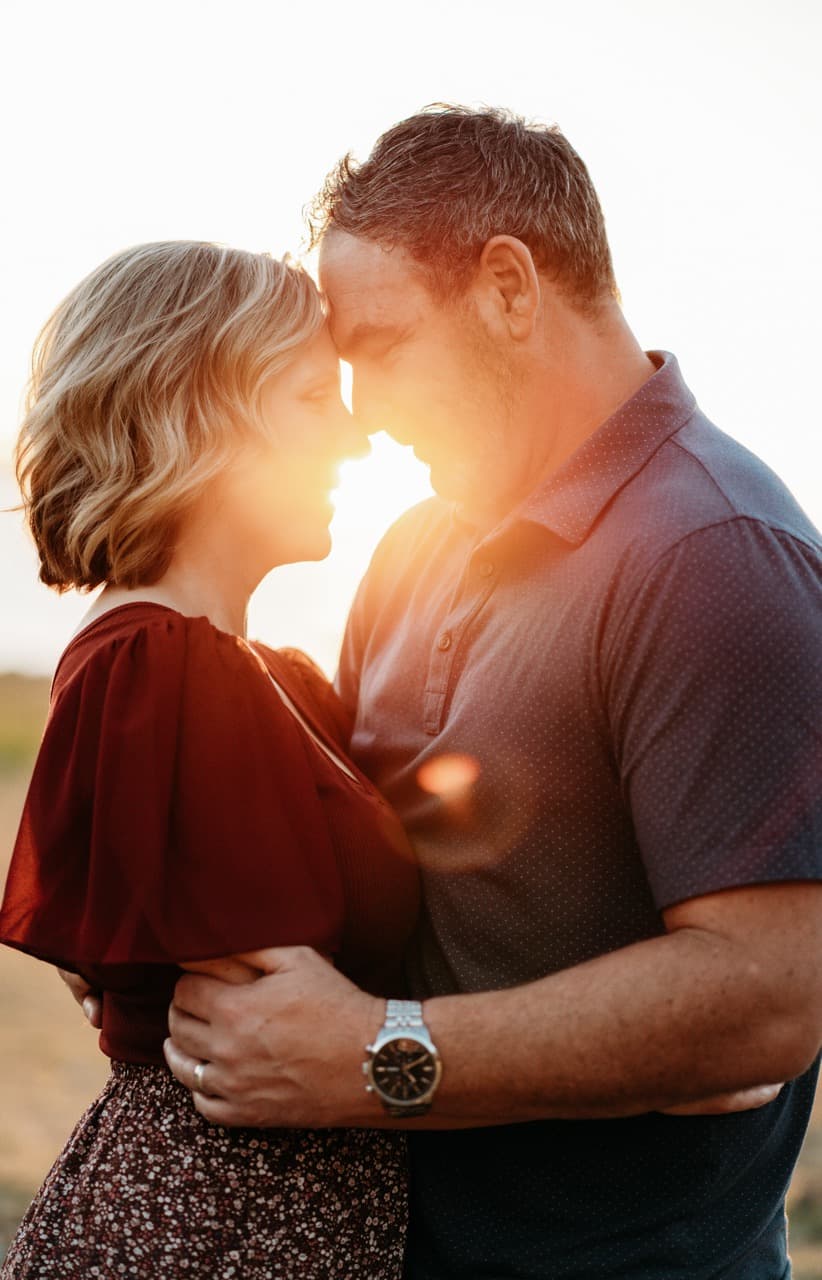 Couple with foreheads touching at sunset