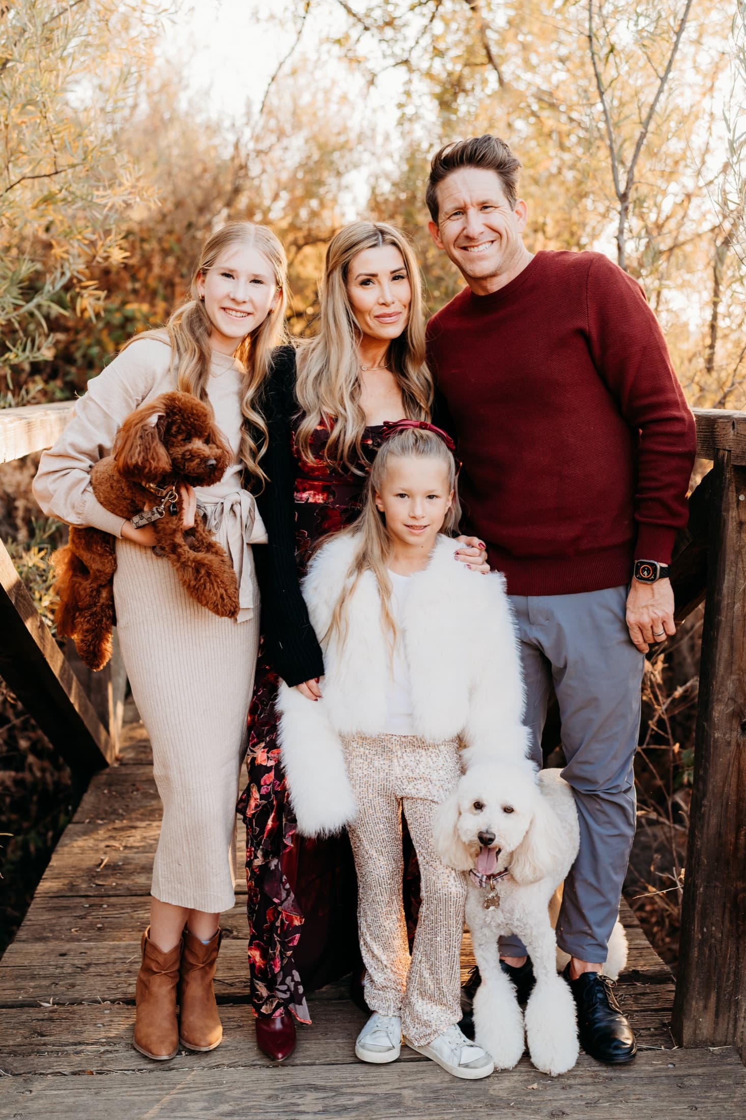 Family with two poodles on a bridge