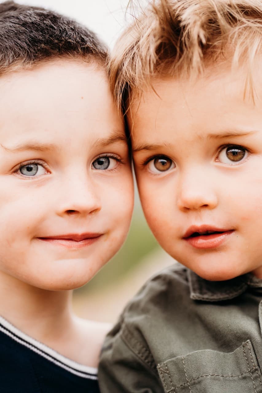 Close-up of two young brothers, foreheads touching, cheek to cheek